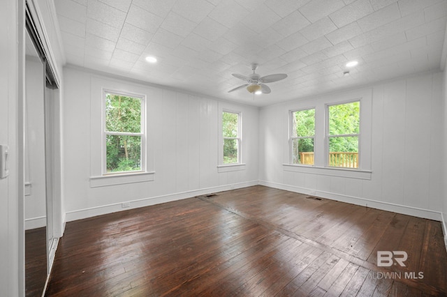 spare room featuring baseboards, a ceiling fan, hardwood / wood-style flooring, and visible vents