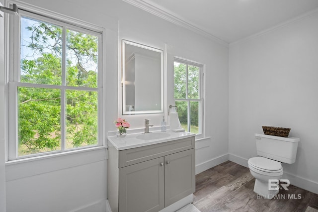 bathroom with crown molding, vanity, toilet, baseboards, and wood finished floors