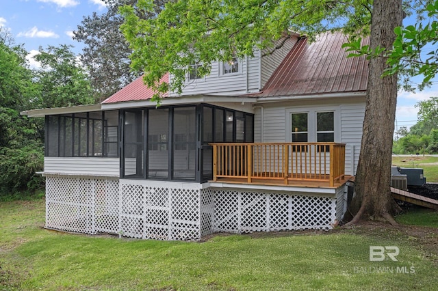 back of house featuring a sunroom and a yard