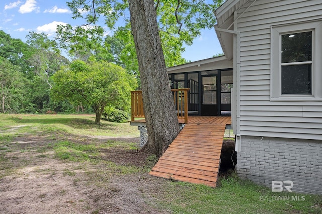 view of yard featuring a wooden deck and a sunroom