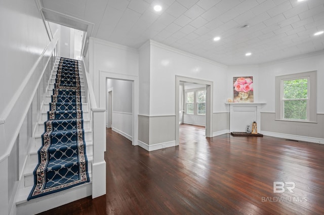 unfurnished living room featuring ornamental molding, a healthy amount of sunlight, and wood finished floors