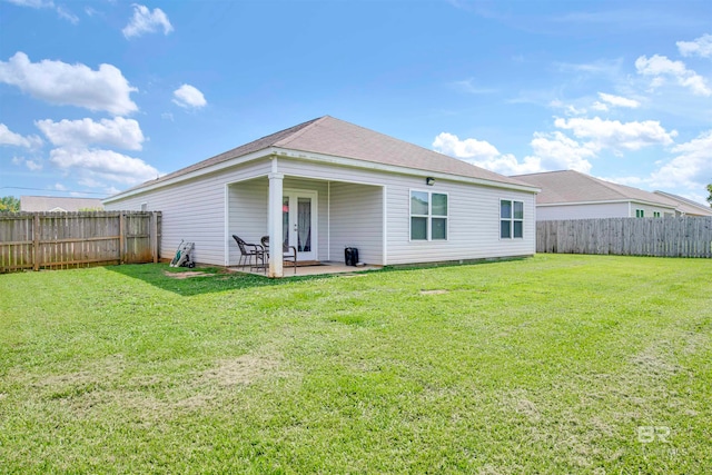 rear view of house with a yard and a patio area