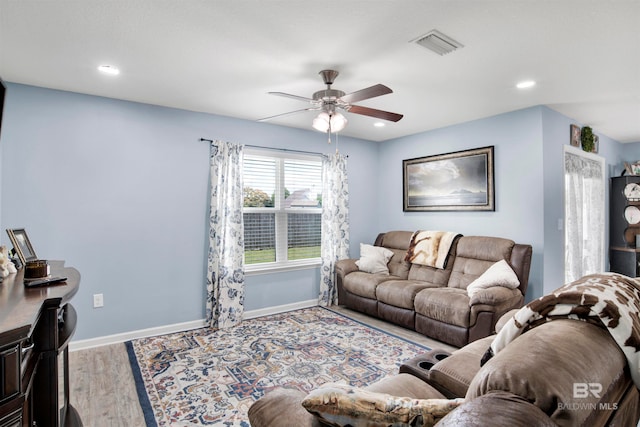 living room featuring light hardwood / wood-style floors and ceiling fan