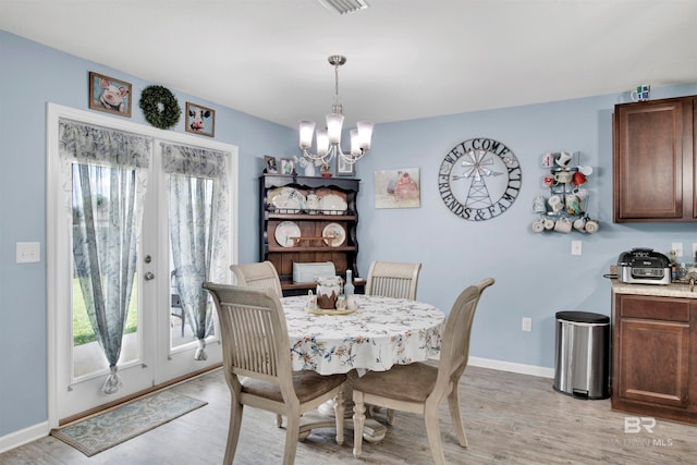 dining area with a notable chandelier and light hardwood / wood-style floors