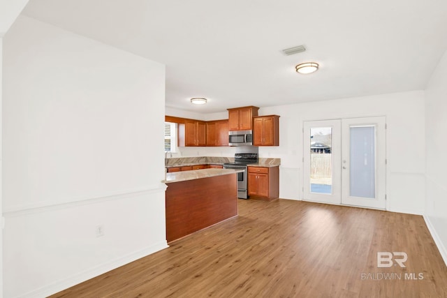 kitchen featuring stainless steel appliances, french doors, and light wood-type flooring