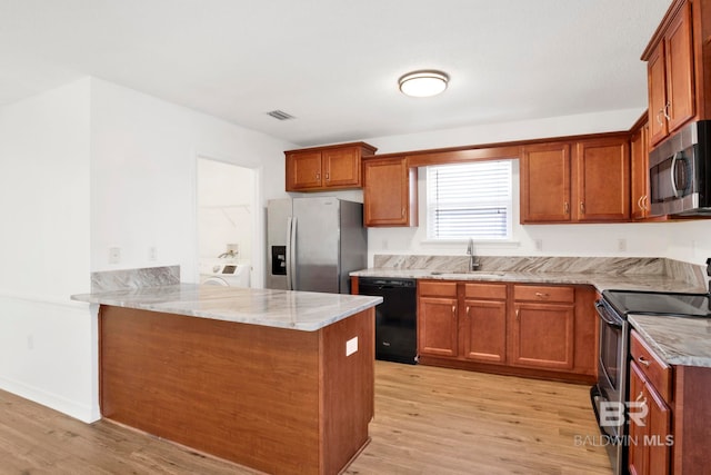 kitchen featuring sink, light stone counters, light wood-type flooring, kitchen peninsula, and stainless steel appliances