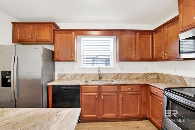 kitchen featuring light stone counters, sink, and stainless steel appliances