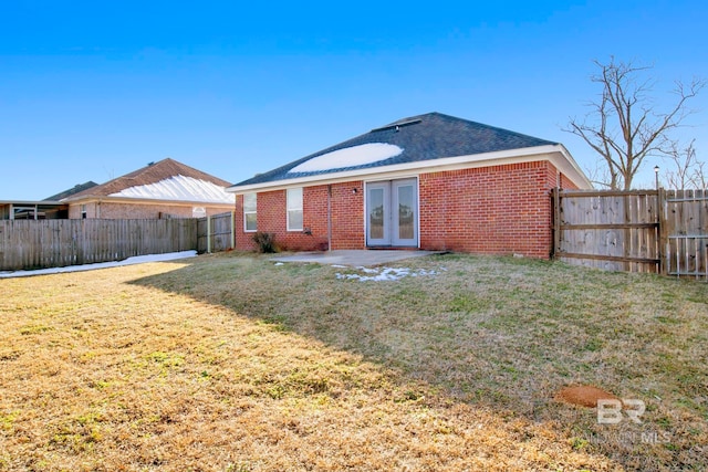 back of property with a yard, a patio area, and french doors