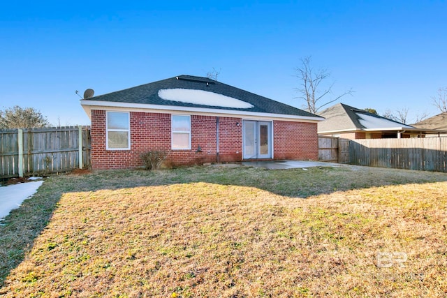 rear view of property featuring a patio area and a lawn