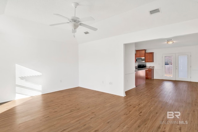 unfurnished living room featuring dark wood-type flooring, ceiling fan, and french doors