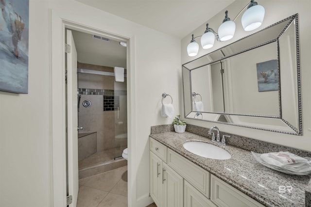 bathroom with toilet, vanity, visible vents, tile patterned floors, and a shower stall