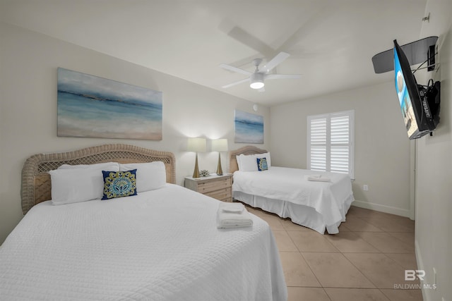 bedroom featuring baseboards, a ceiling fan, and light tile patterned floors