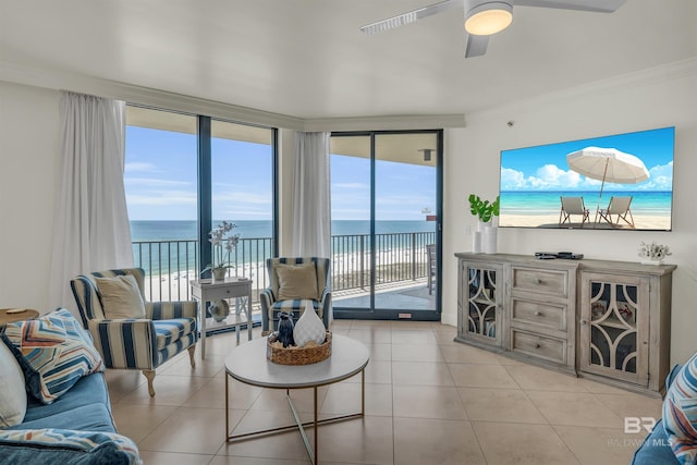 living room featuring a water view, ornamental molding, a healthy amount of sunlight, and light tile patterned flooring