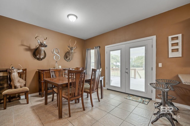 dining space with french doors and light tile patterned floors