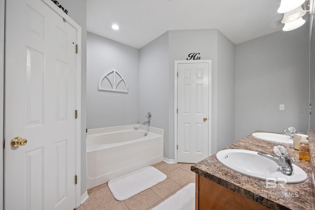 bathroom with tile patterned flooring, vanity, and a tub