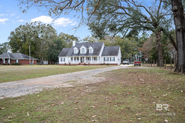 cape cod home featuring a front lawn and a porch