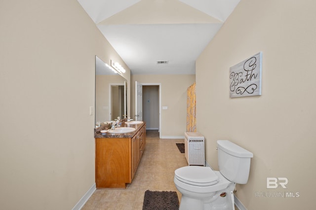 bathroom featuring tile patterned flooring, vanity, vaulted ceiling, and toilet