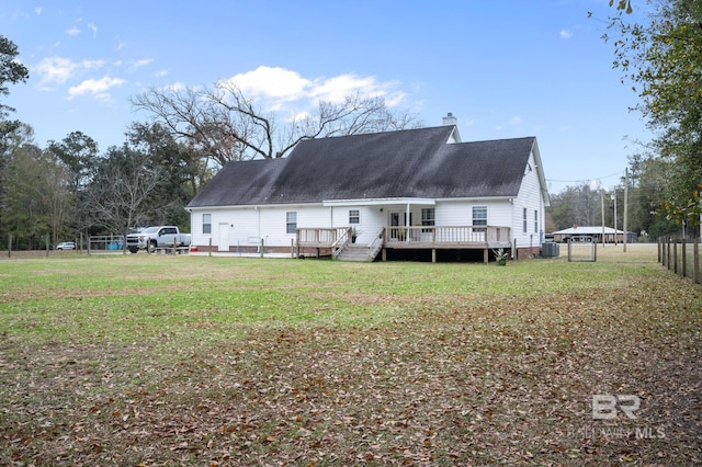 rear view of house with central AC unit, a lawn, and a wooden deck