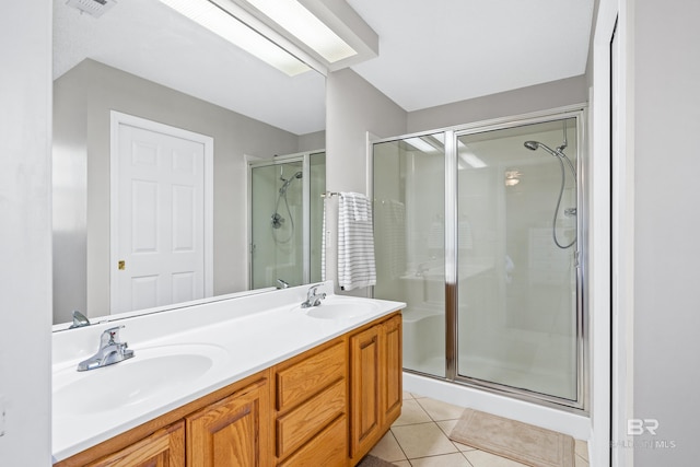 bathroom with tile patterned flooring, vanity, and a shower with door