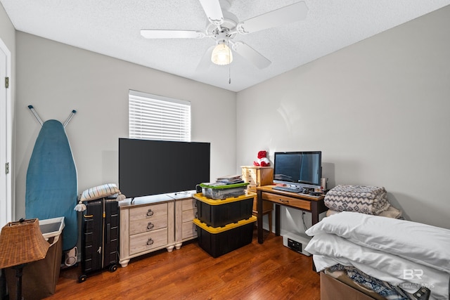 bedroom featuring ceiling fan, dark wood-type flooring, and a textured ceiling