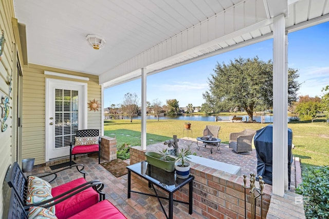 view of patio / terrace with a grill, a water view, and an outdoor living space with a fire pit