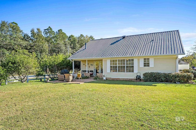 rear view of property featuring a lawn, a patio, and an outdoor hangout area