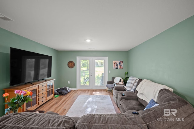 living area featuring french doors, visible vents, baseboards, and wood finished floors