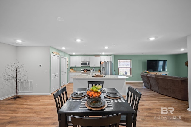 dining area featuring light wood-style flooring, baseboards, visible vents, and recessed lighting