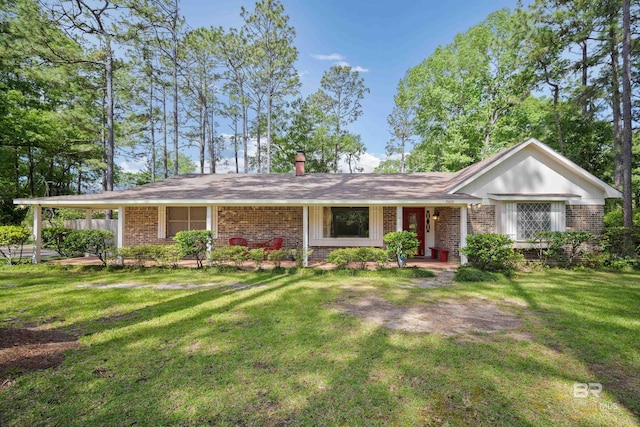 single story home with brick siding, a chimney, and a front lawn