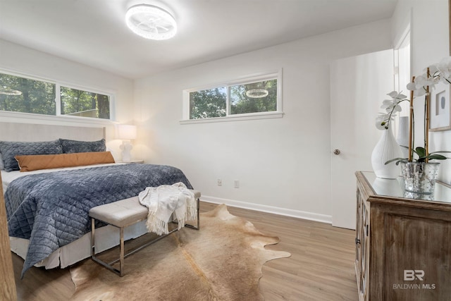 bedroom featuring baseboards and light wood-style floors