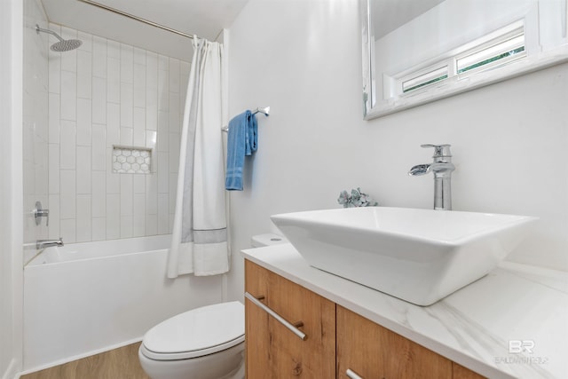 full bathroom featuring hardwood / wood-style floors, shower / tub combo with curtain, vanity, and toilet