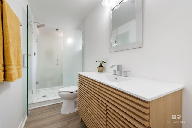 full bathroom with visible vents, toilet, a stall shower, vanity, and wood finished floors