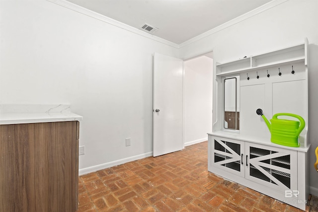 mudroom featuring crown molding, brick floor, visible vents, and baseboards