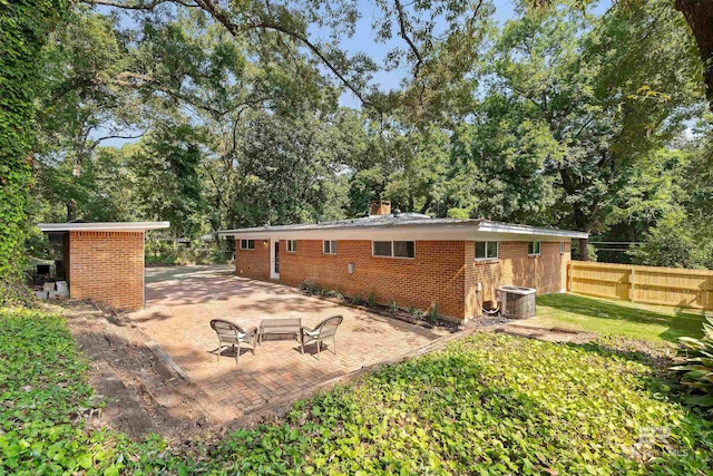 back of property featuring a yard, a patio area, brick siding, and fence