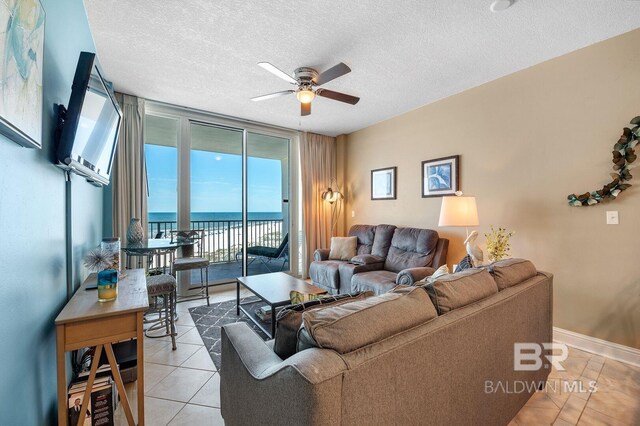 455 E Beach Blvd Unit 402, Gulf Shores, AL 36542 - living room with plenty of natural light, tile patterned floors, floor to ceiling windows, and ceiling fan