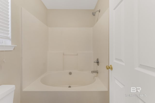 bathroom featuring bathtub / shower combination and toilet