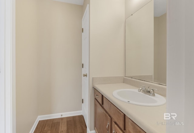 bathroom featuring vanity, baseboards, and wood finished floors