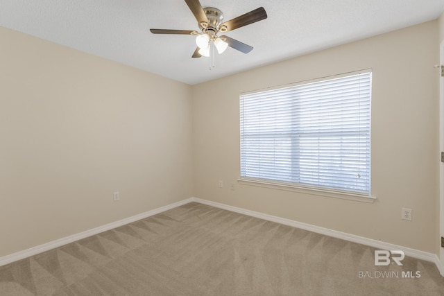 spare room featuring carpet flooring, ceiling fan, and baseboards