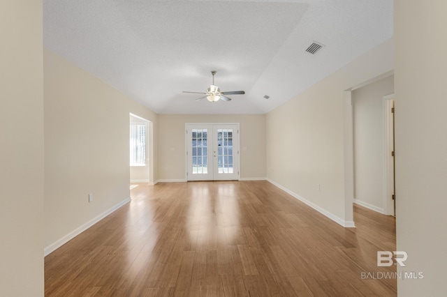 spare room with french doors, visible vents, baseboards, and light wood finished floors