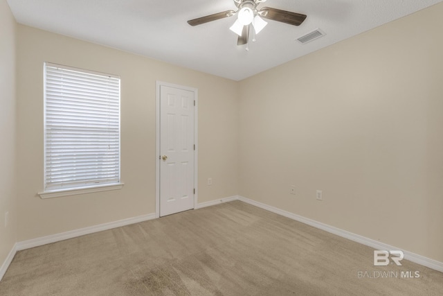 unfurnished room with light carpet, baseboards, visible vents, and a ceiling fan