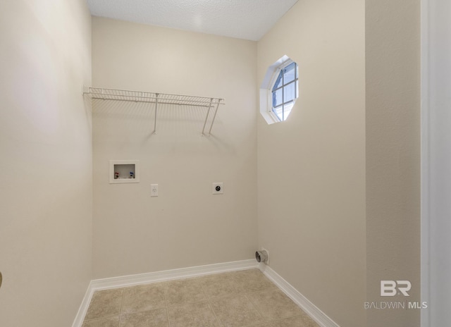 laundry area with washer hookup, hookup for an electric dryer, a textured ceiling, laundry area, and baseboards