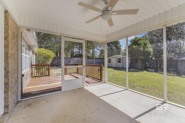 unfurnished sunroom featuring a ceiling fan