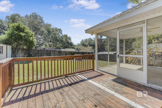 deck with a yard, a fenced backyard, and a sunroom