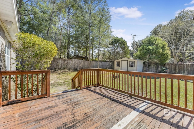 wooden deck featuring a yard, a fenced backyard, a storage shed, and an outbuilding