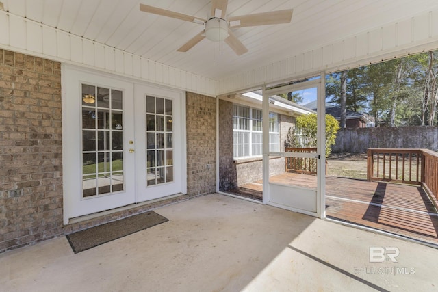 unfurnished sunroom featuring a ceiling fan