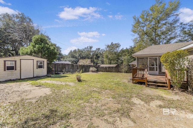 view of yard with a fenced backyard, a storage unit, an outbuilding, and a wooden deck