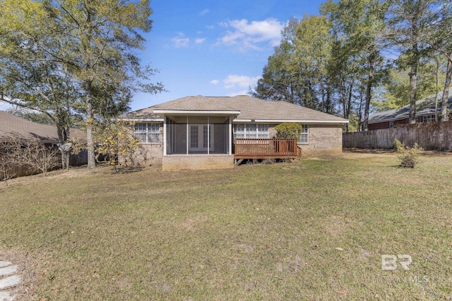 rear view of property with a deck, a lawn, and fence