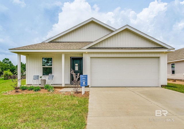 view of front of home with a garage, a porch, and a front lawn