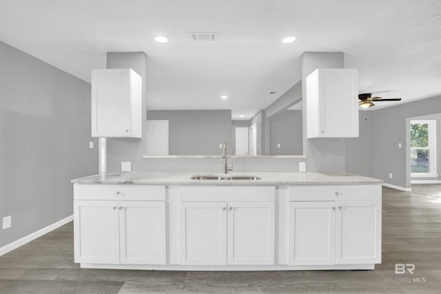 kitchen featuring sink, ceiling fan, light stone countertops, white cabinetry, and kitchen peninsula