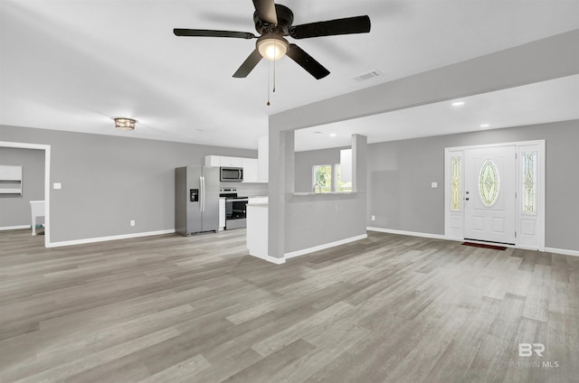 unfurnished living room featuring ceiling fan and light hardwood / wood-style flooring